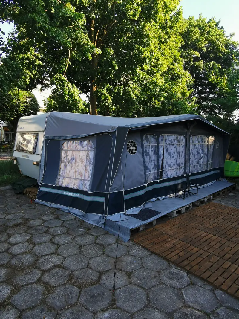 Przyczepa Kaprys wśród drzew — stanowisko w cieniu